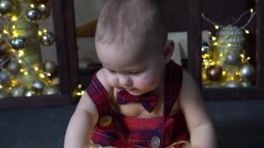 Noel ışıklarıyla bebek oyunu. Yeni yıl tatili için bebek portresi.