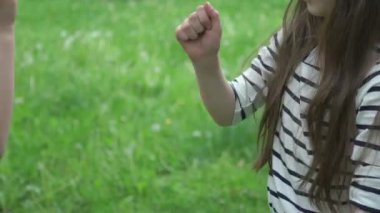 Parkta iki kız kağıt makas oynuyorlar.