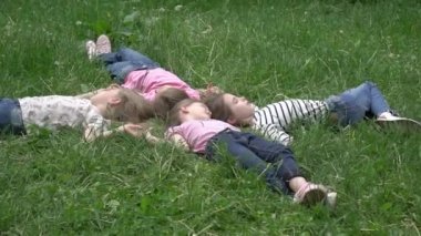 Yaz günü yeşil çimlerin üzerinde uzanan çekici uzun saçlı genç kızlar.