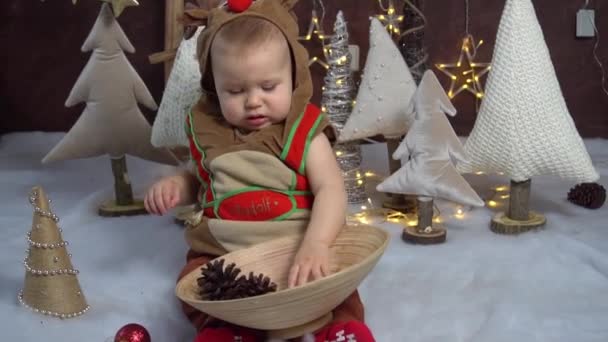 衣装を着た子供がクリスマスツリー クリスマスに座っています — ストック動画