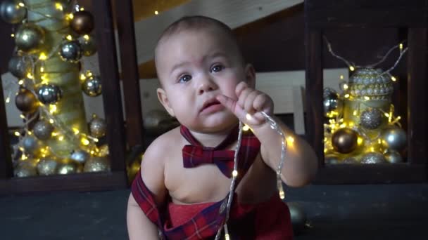 スローモーションハッピー小さな赤ちゃん男の子遊びとともにクリスマスライト — ストック動画