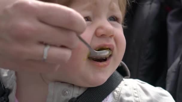 吃被涂污漂亮女婴从室外的勺子吃 — 图库视频影像