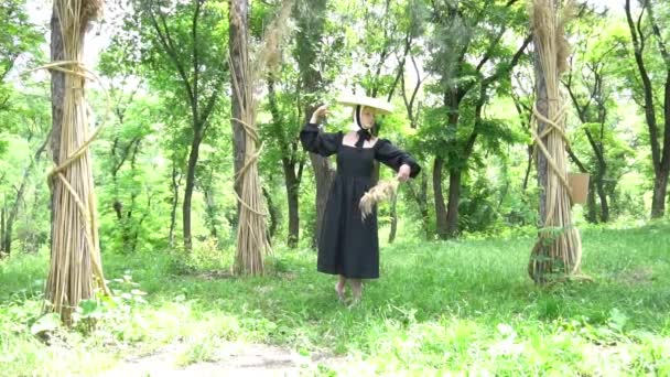身着黑衣 头戴草帽的慢动作姑娘手里拿着一束干植物 — 图库视频影像