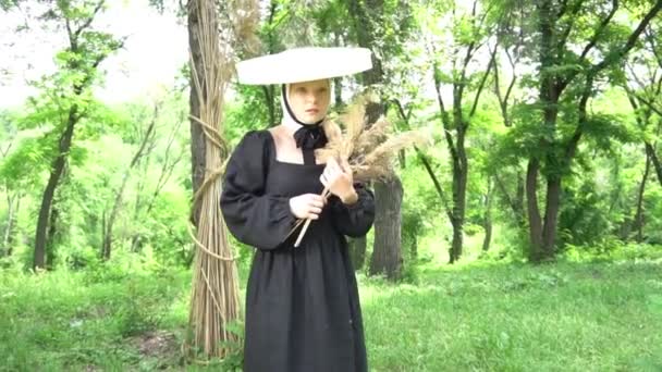 戴着草帽 身穿黑衣 头戴干植物的女孩一个人在公园里散步 — 图库视频影像