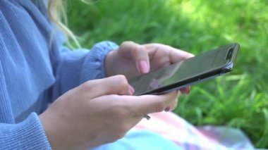 4K Steadycam, parkta cep telefonu kullanan genç bir kadının görüntüsü. 