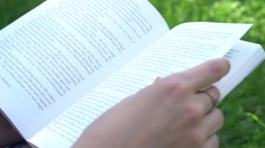 Slow Motion Girl parkta kitap okuyor, mutlu gülümsüyor.