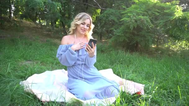 Mutlu Genç Kadın Yeşil Çimlerde Oturuyor Telefonda Konuşuyor Akıllı Telefon — Stok video