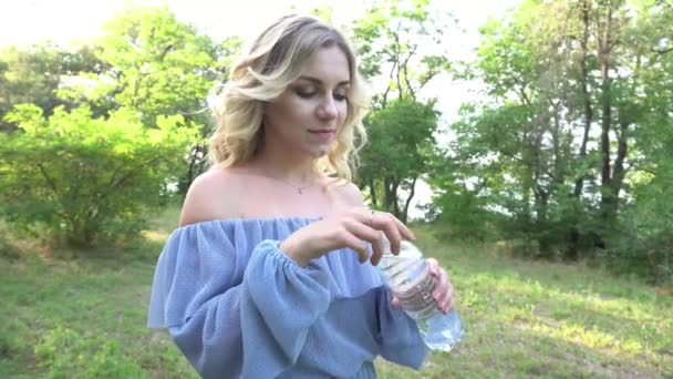 4K若い女性がボトルから水を飲んでいます — ストック動画