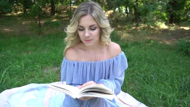 Slow Motion Женщина Читает Книгу Траве — стоковое видео