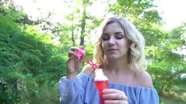 Yavaş çekim, kadının kabarcıklar çıkarıyor.