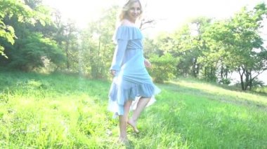Slow Motion Sunny fotoğraf çekimi devam ediyor. Yaz parkında yürüyen şapkalı bir kız.
