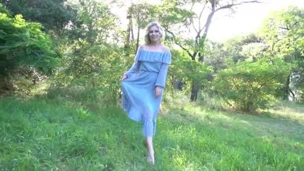 緑の芝生の公園で夏の草原の上を歩くドレスの少女 — ストック動画
