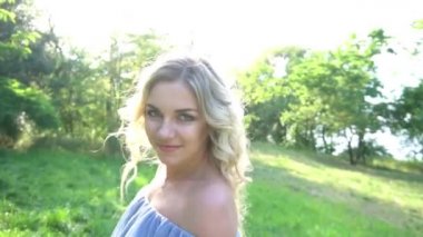 Güneşli fotoğraf çekimi. Yazlık parkta yürüyen şapkalı kız