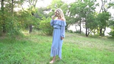 Elektrikli sigara içen kıvırcık kız. Güzel genç kız parkta sigara içiyor. 