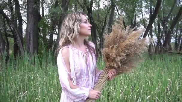 Schöne Blondine Hält Ein Dekor Aus Getrockneten Blumen Der Hand — Stockvideo