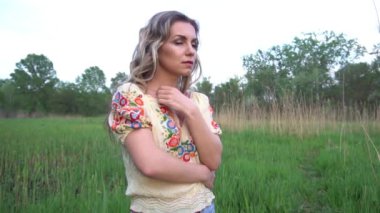 Yavaş çekim. Güzel kadın. Sağlıklı, uzun kıvırcık saçlı, dışarıda poz veren.