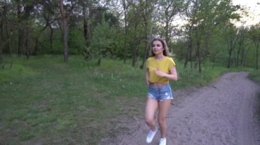 Slow Motion Güzel sportif kadın gün doğumunda parkta koşuyor.