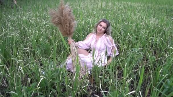 穿着时尚服装的慢动作女人坐在天然草上 — 图库视频影像