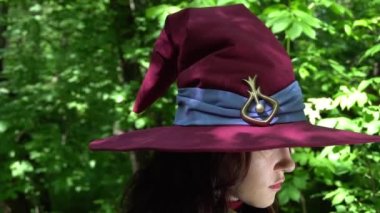 Slow Motion Mutlu Cadılar Bayramı. Cadı şapkalı çekici bir genç kadının portresi.