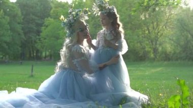 Küçük kız annesine sarılıyor ve kulağına bir şeyler fısıldıyor.