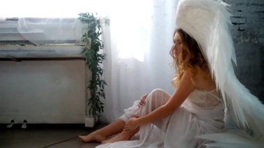 güzel genç model stüdyoda oturan büyük melek kanatlı