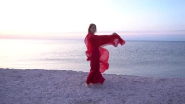 Slow Motion. Uçan kırmızı elbiseli, plajlı güzel kadın.