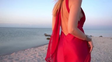 Slow Motion Genç kadın kırmızı kumaşla sahilde