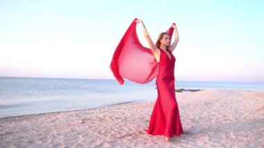Slow Motion Beautiful girl in a bright red dress by the sea. 