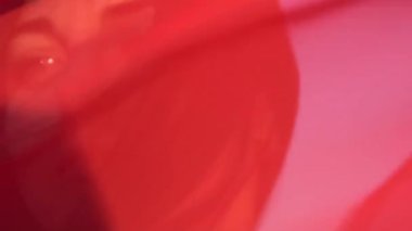 Yavaş çekim. Kırmızı elbiseli, seksi, esmer bir kadının portresi.