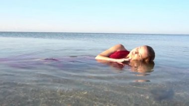 Ağır çekim seksi kadın okyanusta yatıyor..