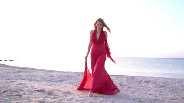 一个穿着红色长裙的漂亮的性感女人在海面上摆姿势 — 图库视频影像