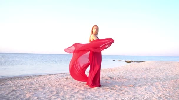 スローモーション女性で赤いドレスで海の近くに立って — ストック動画