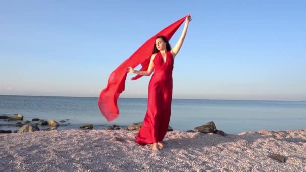 穿着红色连衣裙的慢动作女人在海边或海边的风中 — 图库视频影像
