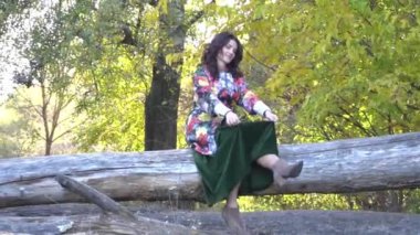 Sonbahar ormanında uzun siyah saçlı bir kadın.