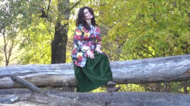 Sonbahar parkında, sarı ağaçların altında, sarı yaprakların üzerinde güzel bir kadın.