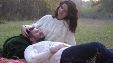 Romantic Couple Sitting on Fall Foliage in Autumn