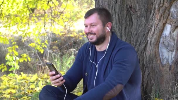 Slow Motion Happy Caucasian Man Listening Music Autumn Park — Stock Video