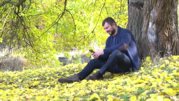 Lassú Mozgású Ember Üzenetet Telefonjába Őszi Parkban — Stock videók