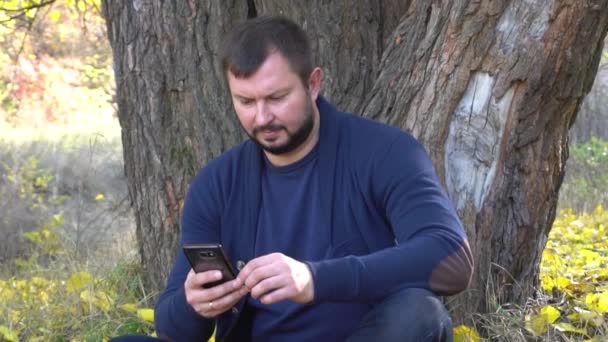 Retrato Del Hombre Excitado Sosteniendo Teléfono Inteligente Parque Otoño — Vídeo de stock