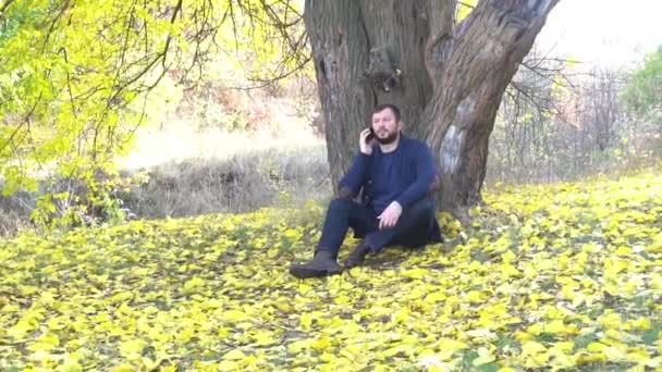 Hombre Habla Por Teléfono Mira Lado Parque Otoño — Vídeos de Stock