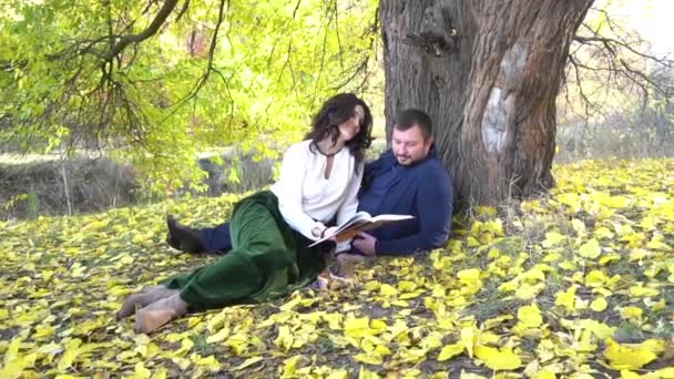 Slow Motion Two People Relaxing Reading Book Autumn Park — Video