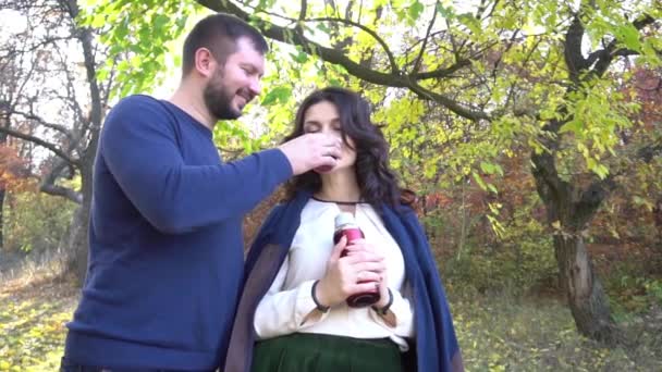 スローモーション秋の森 魔法瓶 カップの美しいカップル — ストック動画