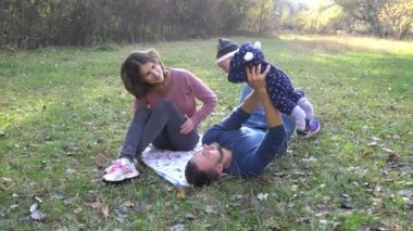 Young family and their toddler little boy having a great time in the forest