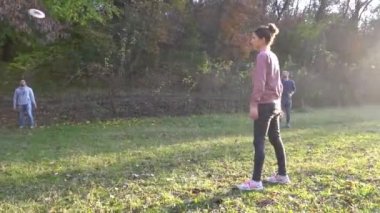 Young people in casual wear playing while spending carefree time outdoors