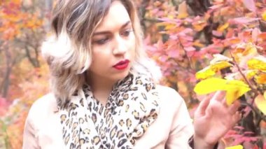 Parkta mutlu bir kız Akçaağaç sarısı yapraklarıyla, sonbahar zamanı