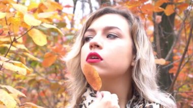 Slow Motion Autumn kadını sonbahar parkında. Sıcak güneşli hava. Sonbahar kavramı