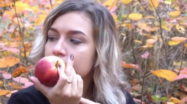 Sonbaharda parkta kırmızı elma tutan güzel sarışın karizmatik kız, diyet.