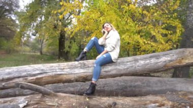 Slow Motion Autumn kadını sonbahar parkında. Sıcak güneşli hava. Sonbahar kavramı