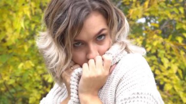 Slow Motion gülen kadın sonbahar sarı yapraklarıyla oynuyor. Tarz sahibi kadın eğleniyor