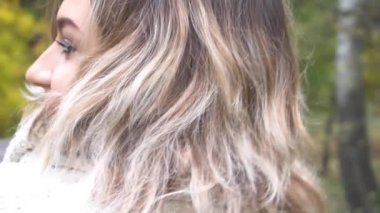 Slow Motion mutlu kadın sonbahar günbatımında parkta gülümsüyor